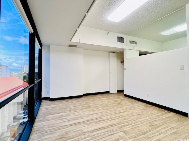 1188 Bishop St Unit 601, Honolulu, HI 96813 - unfurnished room with light wood finished floors and a textured ceiling