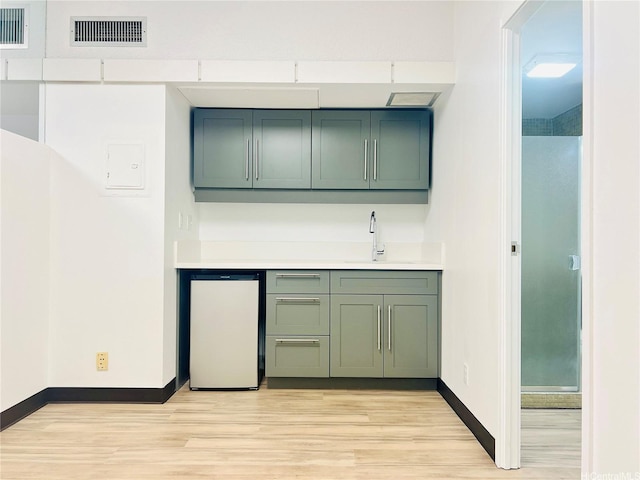 1188 Bishop St Unit 601, Honolulu, HI 96813 - kitchen featuring green cabinets, light wood-style floors, and light countertops