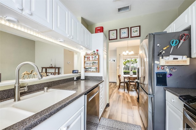 91-1059 Keoneula Blvd Unit F3, Ewa Beach, HI 96706 - kitchen featuring stainless steel appliances, white cabinets, dark countertops, light wood-style floors, and a chandelier