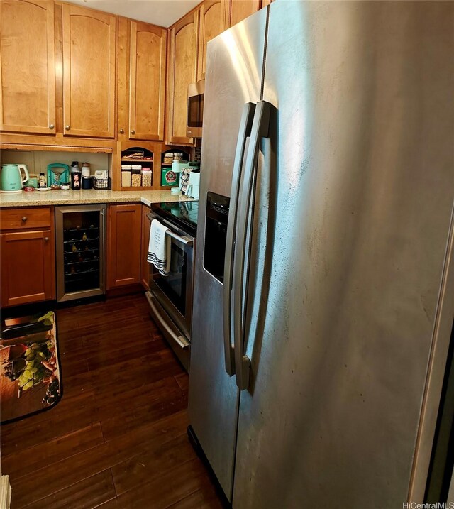 kitchen featuring stainless steel appliances, beverage cooler, dark wood finished floors, and light countertops