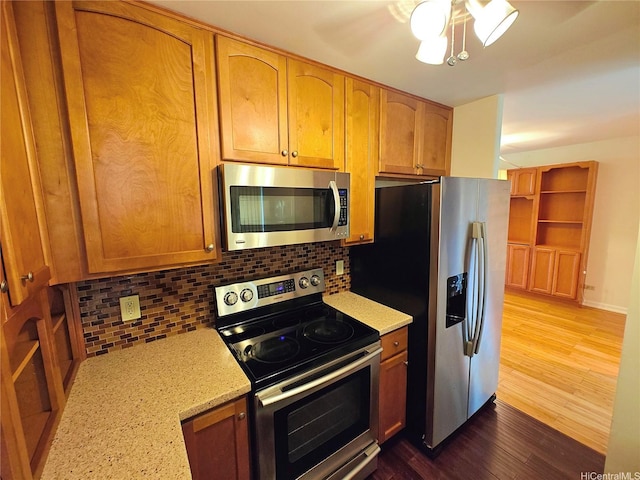 965 Prospect St Unit 307, Honolulu, HI 96822 - kitchen with appliances with stainless steel finishes, tasteful backsplash, dark wood-type flooring, light stone counters, and ceiling fan