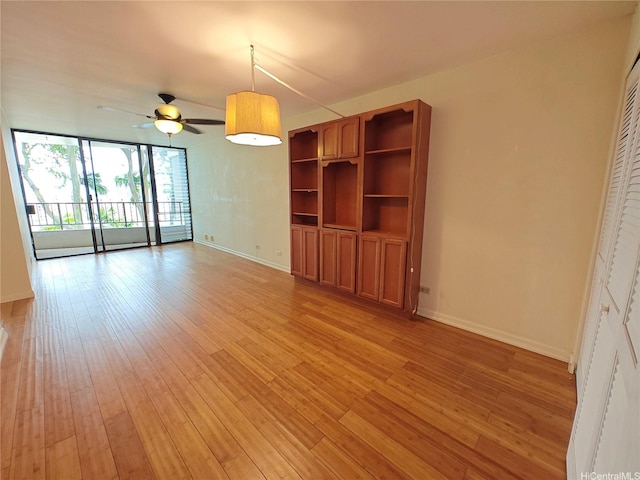 965 Prospect St Unit 307, Honolulu, HI 96822 - unfurnished living room with baseboards, a ceiling fan, light wood finished floors, and expansive windows