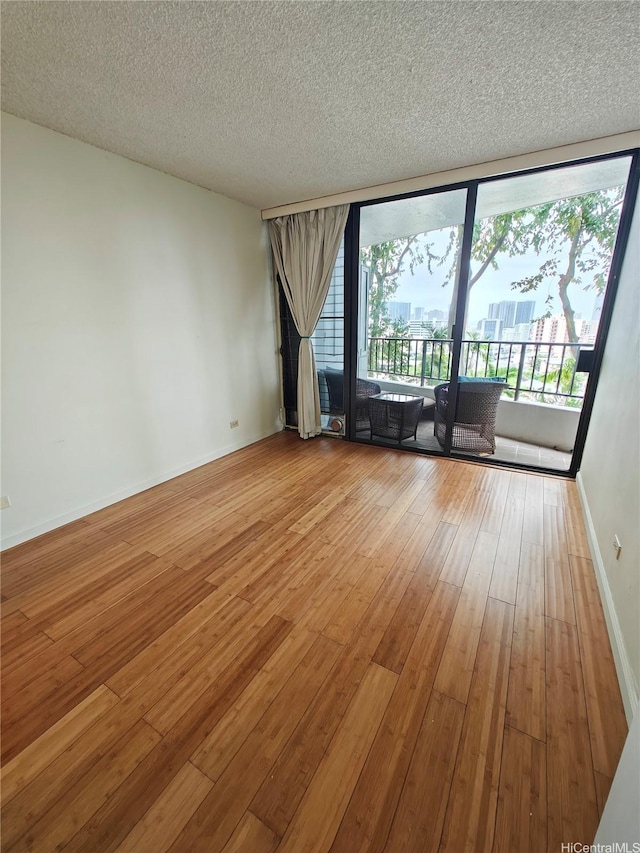 965 Prospect St Unit 307, Honolulu, HI 96822 - spare room with wood-type flooring, baseboards, and a textured ceiling