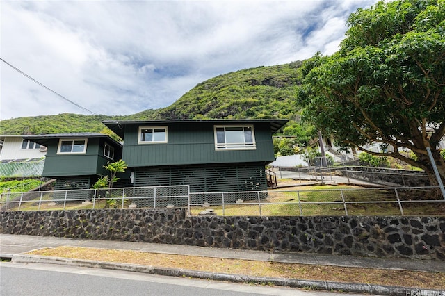 view of front facade featuring a fenced backyard and a mountain view