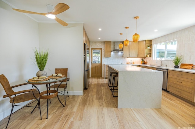 kitchen featuring wall chimney range hood, open shelves, a kitchen island, appliances with stainless steel finishes, and light countertops