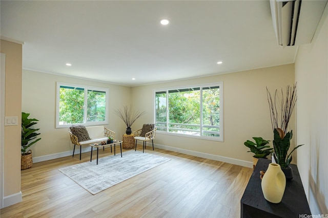 living area with light wood-style flooring, baseboards, and recessed lighting