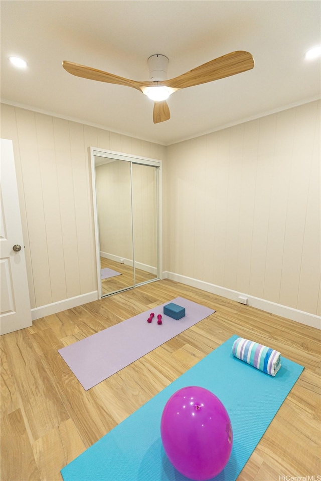 workout room featuring wood finished floors, baseboards, and a ceiling fan