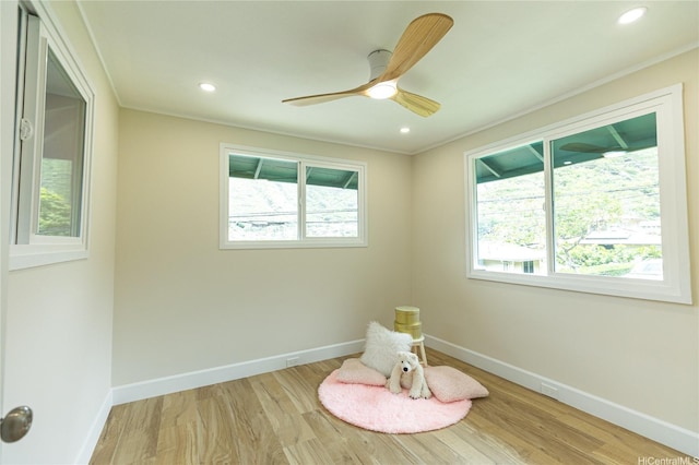 recreation room featuring wood finished floors, baseboards, and ornamental molding