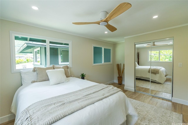 bedroom featuring a closet, ornamental molding, recessed lighting, wood finished floors, and baseboards