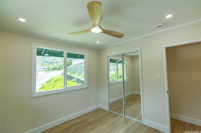 unfurnished bedroom featuring light wood-type flooring, a closet, baseboards, and recessed lighting