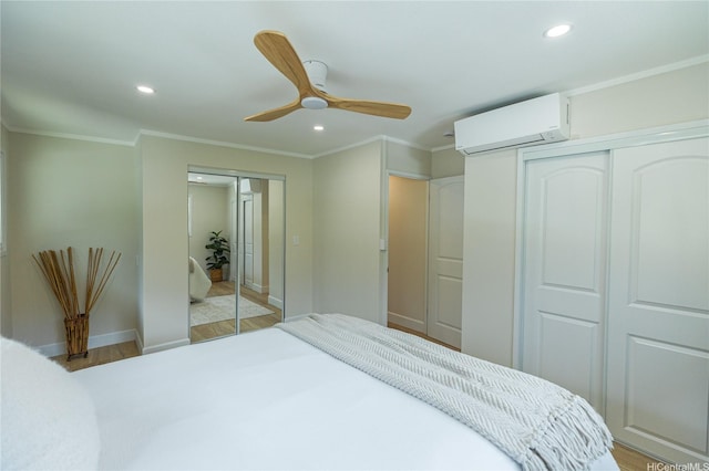 bedroom with baseboards, a wall mounted air conditioner, recessed lighting, crown molding, and light wood-style floors