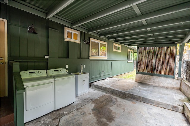 clothes washing area with washer and dryer, laundry area, and a sink