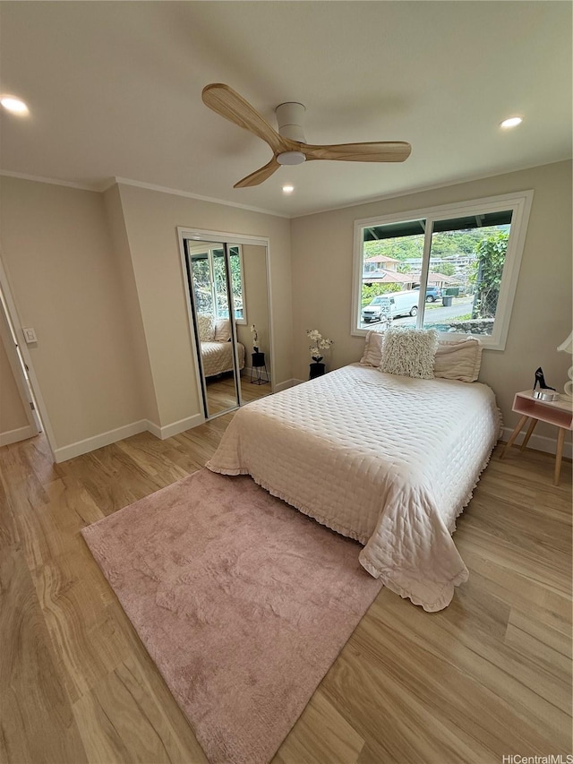 bedroom with a closet, light wood-style flooring, recessed lighting, and baseboards