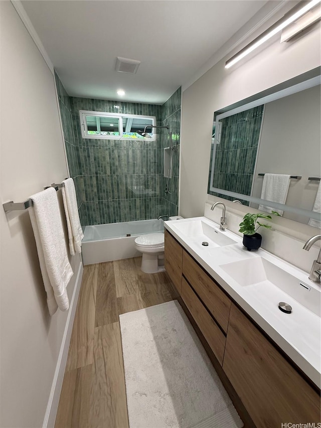 full bathroom featuring double vanity, shower / bathtub combination, a sink, and toilet