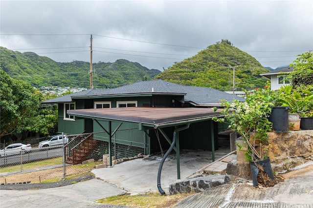 view of front of home featuring a mountain view, fence, and stairs