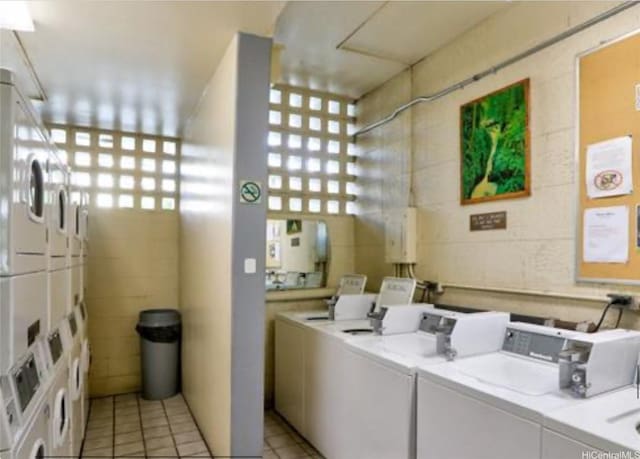 common laundry area featuring washing machine and dryer, light tile patterned floors, and stacked washing maching and dryer