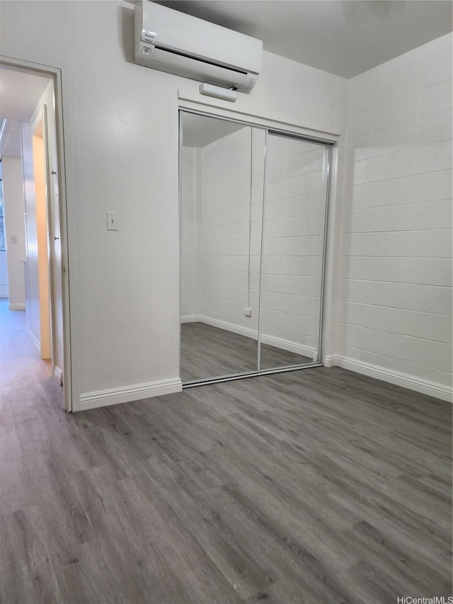 2050 Nuuanu Ave Unit 109, Honolulu, HI 96817 - unfurnished bedroom with a wall mounted AC, wood finished floors, and a closet