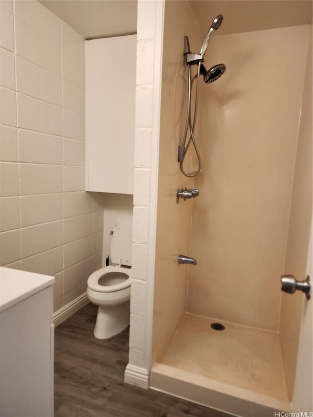 2050 Nuuanu Ave Unit 109, Honolulu, HI 96817 - full bathroom with a shower stall, wood finished floors, vanity, and tile walls