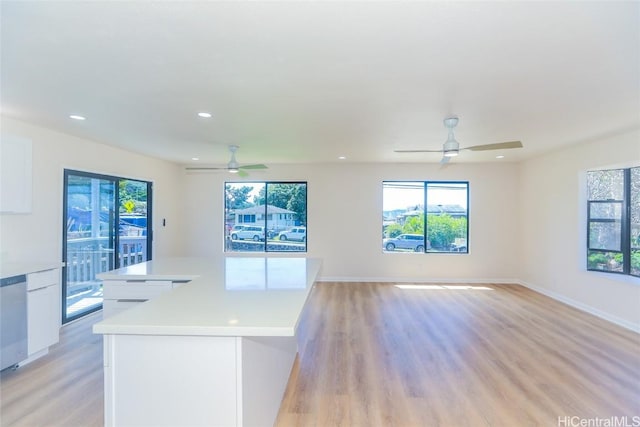kitchen with white cabinetry, light countertops, a ceiling fan, and a healthy amount of sunlight