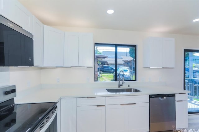kitchen with a sink, light countertops, white cabinets, and stainless steel appliances