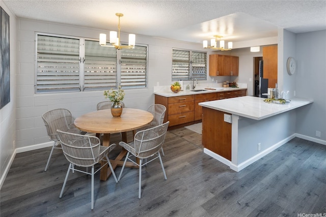 94-313 Ulukoa St, Mililani, HI 96789 - kitchen featuring brown cabinetry, a sink, dark wood-type flooring, a chandelier, and a textured ceiling
