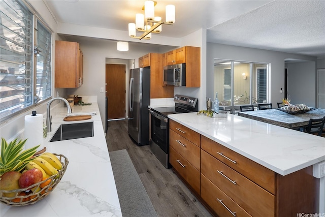 94-313 Ulukoa St, Mililani, HI 96789 - kitchen with stainless steel appliances, a sink, a peninsula, brown cabinetry, and dark wood-style flooring