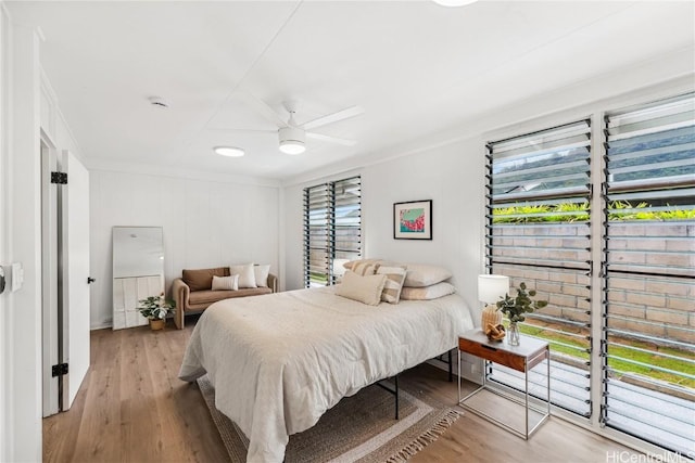 bedroom with ornamental molding, a ceiling fan, and light wood-style floors