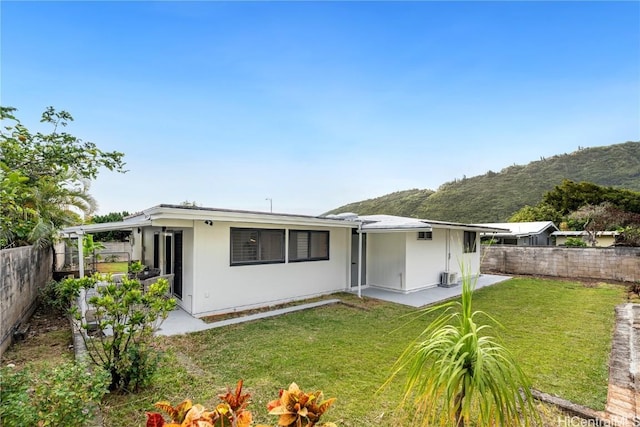 rear view of property with a yard and a fenced backyard