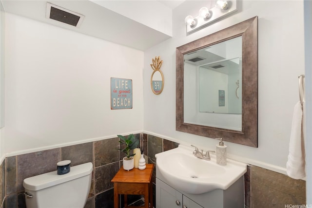 430 Keoniana St Unit 204, Honolulu, HI 96815 - half bathroom featuring vanity, visible vents, a wainscoted wall, toilet, and tile walls