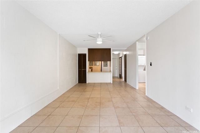 spare room with light tile patterned floors, ceiling fan, and a textured ceiling