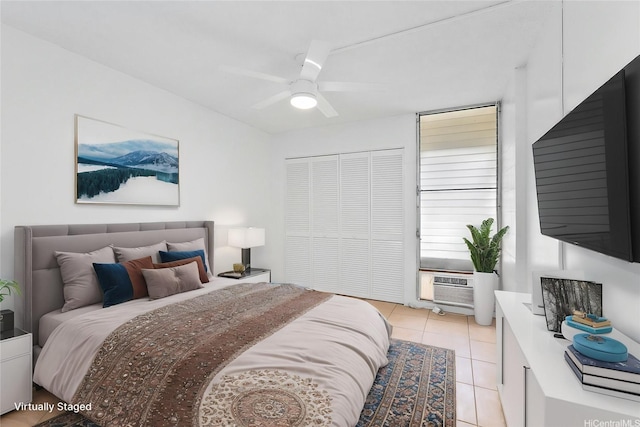 bedroom with ceiling fan, cooling unit, a closet, and light tile patterned flooring