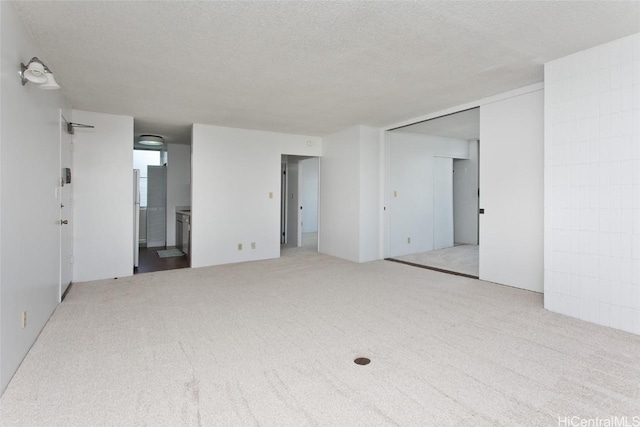 carpeted empty room featuring a textured ceiling