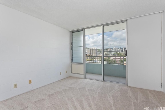 carpeted spare room featuring a view of city and a textured ceiling