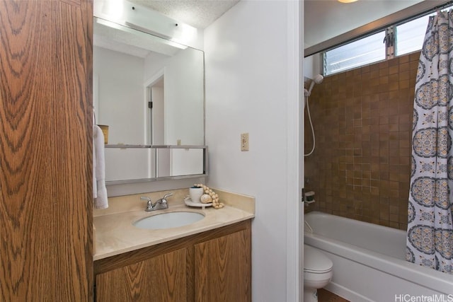 full bathroom featuring toilet, a textured ceiling, vanity, and shower / bath combo with shower curtain