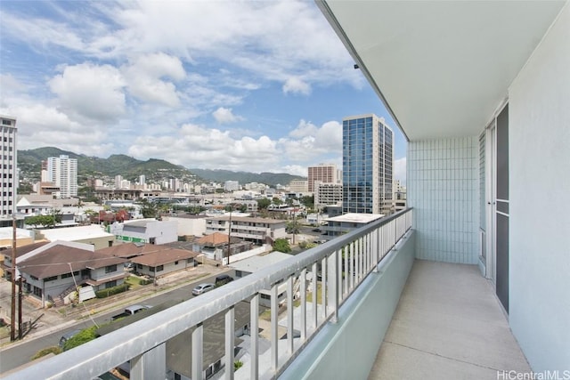 balcony with a mountain view and a view of city
