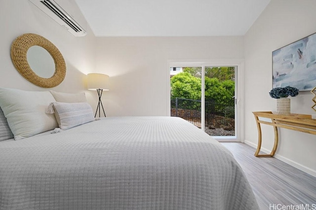 1782 Laukahi St, Honolulu, HI 96821 - bedroom featuring lofted ceiling, wood finished floors, baseboards, a wall mounted AC, and access to outside