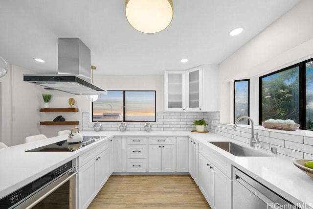 1782 Laukahi St, Honolulu, HI 96821 - kitchen featuring island exhaust hood, light countertops, backsplash, a sink, and white cabinetry