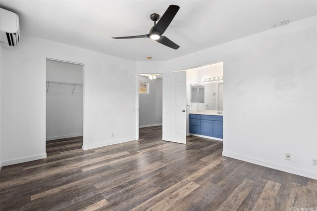 91-241 Makalauna Pl Unit 15, Ewa Beach, HI 96706 - unfurnished bedroom featuring a wall unit AC, dark wood-style flooring, a closet, ensuite bathroom, and a ceiling fan