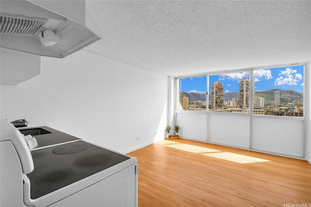 2211 Ala Wai Blvd Unit 1106, Honolulu, HI 96815 - kitchen featuring electric range, a textured ceiling, a city view, light wood-type flooring, and a sink