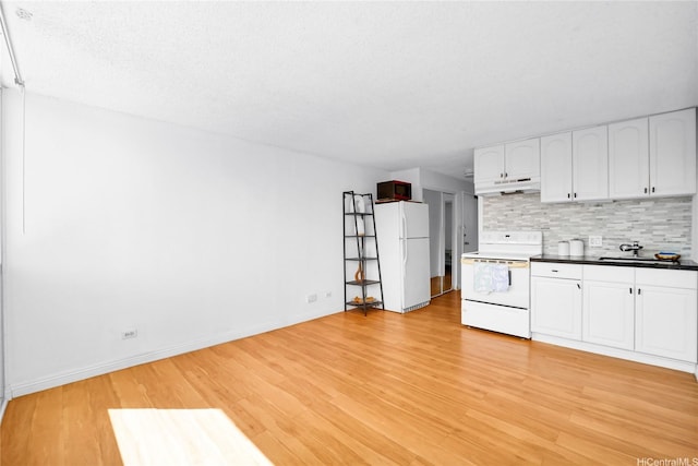 2211 Ala Wai Blvd Unit 1106, Honolulu, HI 96815 - kitchen with white appliances, under cabinet range hood, backsplash, dark countertops, and white cabinetry