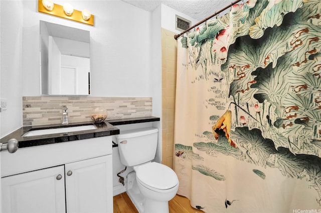 2211 Ala Wai Blvd Unit 1106, Honolulu, HI 96815 - bathroom with toilet, vanity, backsplash, wood finished floors, and a textured ceiling