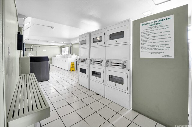 2211 Ala Wai Blvd Unit 1106, Honolulu, HI 96815 - kitchen featuring stacked washer and clothes dryer, light tile patterned floors, washer and dryer, and white cabinets