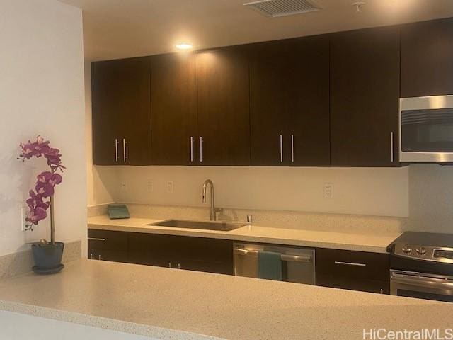 kitchen featuring a sink, visible vents, modern cabinets, light countertops, and appliances with stainless steel finishes
