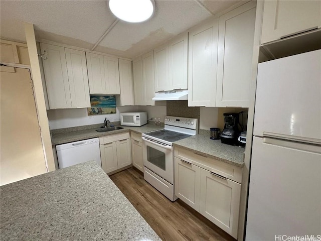 2333 Kapiolani Blvd Unit 905, Honolulu, HI 96826 - kitchen with a sink, light countertops, white appliances, under cabinet range hood, and wood finished floors