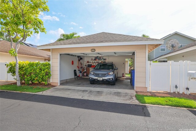 view of front of house with a garage, fence, a shingled roof, and driveway