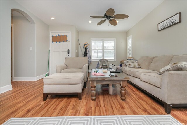 living area with ceiling fan, wood finished floors, arched walkways, recessed lighting, and baseboards