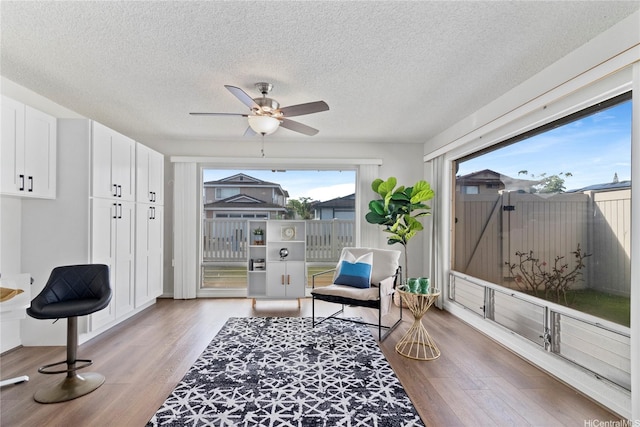 94-1041 Puana St, Waipahu, HI 96797 - living area featuring light wood-style floors, a textured ceiling, and a ceiling fan