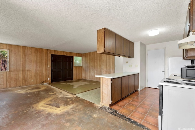 kitchen with electric range, a peninsula, black microwave, and wood walls