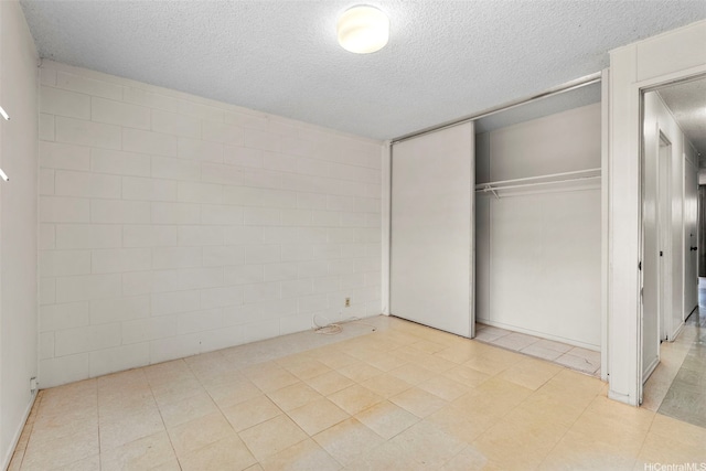 unfurnished bedroom featuring a closet and a textured ceiling