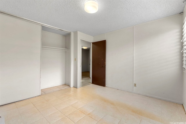 unfurnished bedroom featuring a textured ceiling and a closet